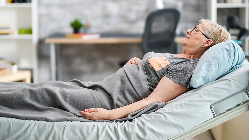 Một cụ bà nằm liệt giường.