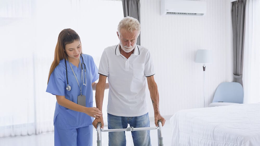 Hỗ trợ người cao tuổi đi lại bằng cách sử dụng dụng cụ hỗ trợ đi bộ.